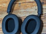 an image of a pair of black headphones on a wooden surface
