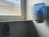 a window in the corner of a room that has a water dispenser on it