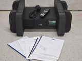 une télécommande et un cahier posés par terre