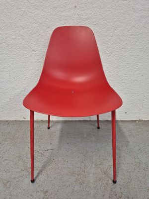 une chaise rouge posée sur un sol en béton