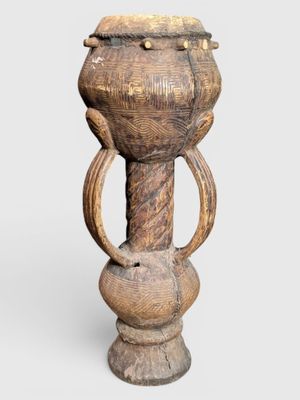 an old wooden vase sitting on top of a white surface