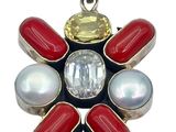 a close up of a red, white, and blue flower pendant
