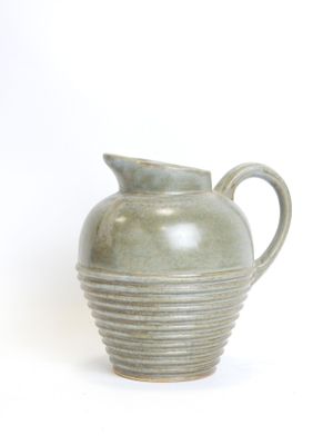 a green vase that is sitting on a white surface