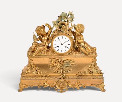 a gold clock with angels on it on a white background