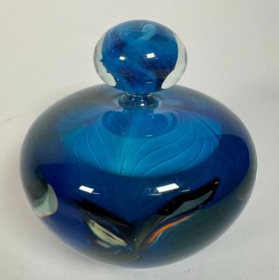 a blue glass jar with a blue swirl design on it