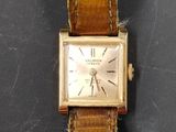 gros plan d'une montre-bracelet avec un bracelet en cuir marron