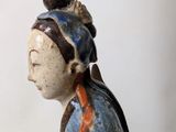 a small statue of a woman sitting on a table