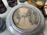 a silver plate with a picture of a woman on it