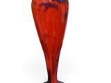 a red and blue vase sitting on a white surface