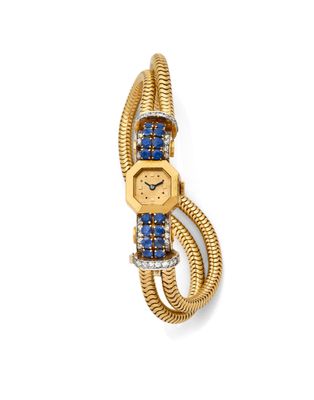 un gros plan d'une montre en or sertie de pierres bleues