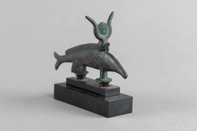 un gros plan d'une statue représentant un animal posée sur un socle noir