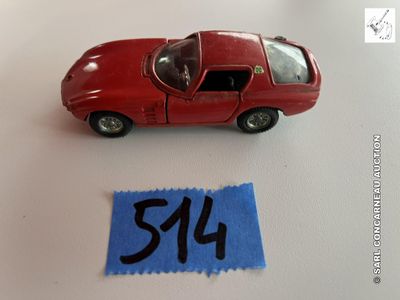 une petite voiture rouge posée à côté d'une feuille de papier bleue