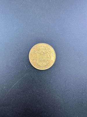 gros plan d'une pièce d'or sur une surface noire