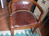 a brown leather chair sitting on a rug in a room