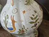a white vase sitting on top of a wooden table