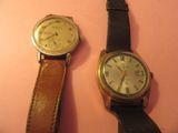 deux montres posées l'une à côté de l'autre sur une surface rose
