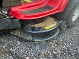 a red lawn mower that is sitting on the ground