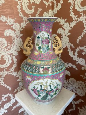 un vase posé sur un socle devant un mur recouvert de papier peint