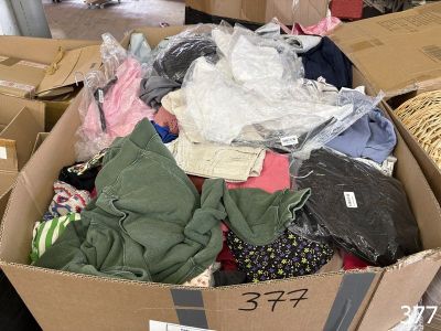 a cardboard box full of clothes on the floor