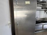 a stainless steel refrigerator in a kitchen with pots and pans on the counter
