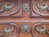 a close up of a wooden chest of drawers with metal handles