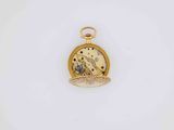 a close up of a pocket watch on a white surface