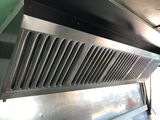 a metal vent hood in the middle of a kitchen