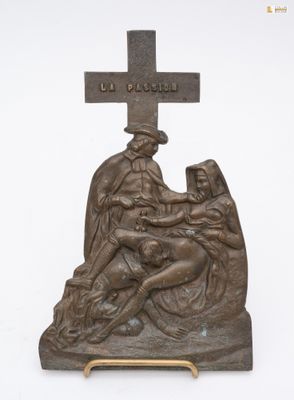 statue en bronze représentant une femme agenouillée sur une croix, aux côtés d'un homme tenant un bébé dans ses bras