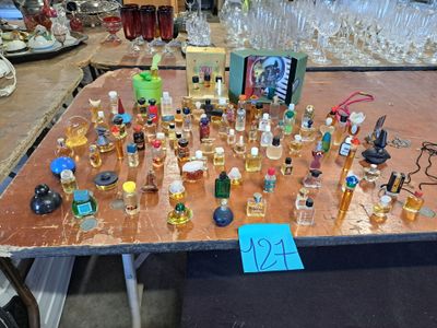 many bottles of perfume on a table with a price tag