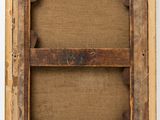an old wooden frame with a piece of wood hanging from it ' s side