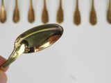 a person holding a spoon in front of a row of spoons