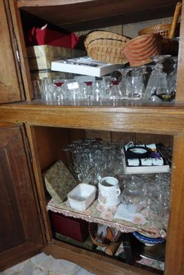 une armoire en bois sur laquelle sont disposés de nombreux objets en verre