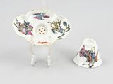 a small cup and saucer sitting next to each other on a table