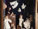 une vitrine contenant des poupées, posée sur une étagère
