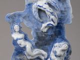 a blue and white sculpture of a group of people on a rock