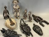 de nombreux objets africains posés sur une table blanche