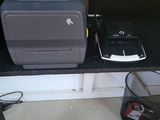 a printer sitting on a shelf next to a trash can