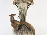 a bird that is sitting on a vase on a white background