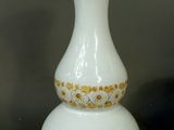 a white vase with a green and yellow design on it