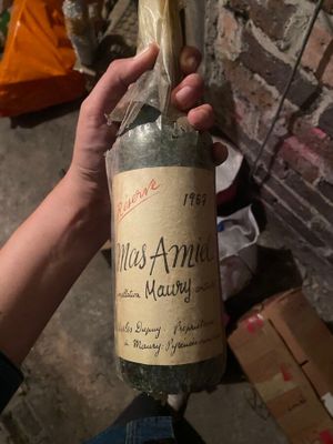 une personne tenant une bouteille de vin à la main
