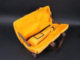 a yellow case with a tool in it on a black surface