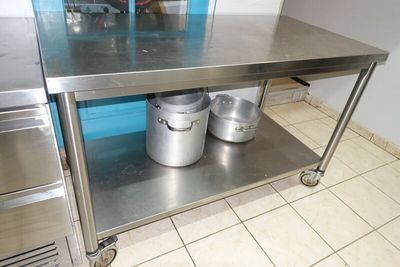 une table en acier inoxydable sur laquelle sont posés deux seaux