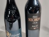 two bottles of wine sitting next to each other on a table