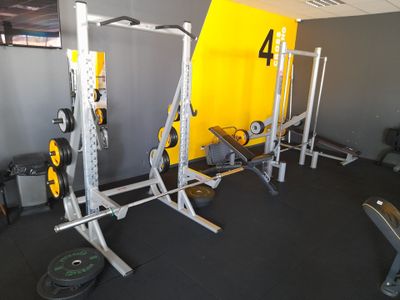 une salle de sport avec un mur jaune et un sol noir