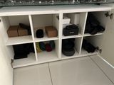 a white cabinet with a bunch of shoes and bags on it