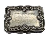 une boîte en argent finement ouvragée sur laquelle est apposée une plaque portant l'inscription suivante :