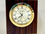 une petite horloge en bois avec des chiffres romains