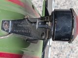 a close up of a green motorcycle with a red stripe on it