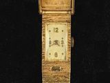 une photo d'une montre-bracelet en or au cadran carré