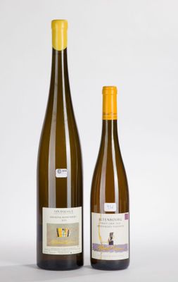 two bottles of wine sitting next to each other on a white surface